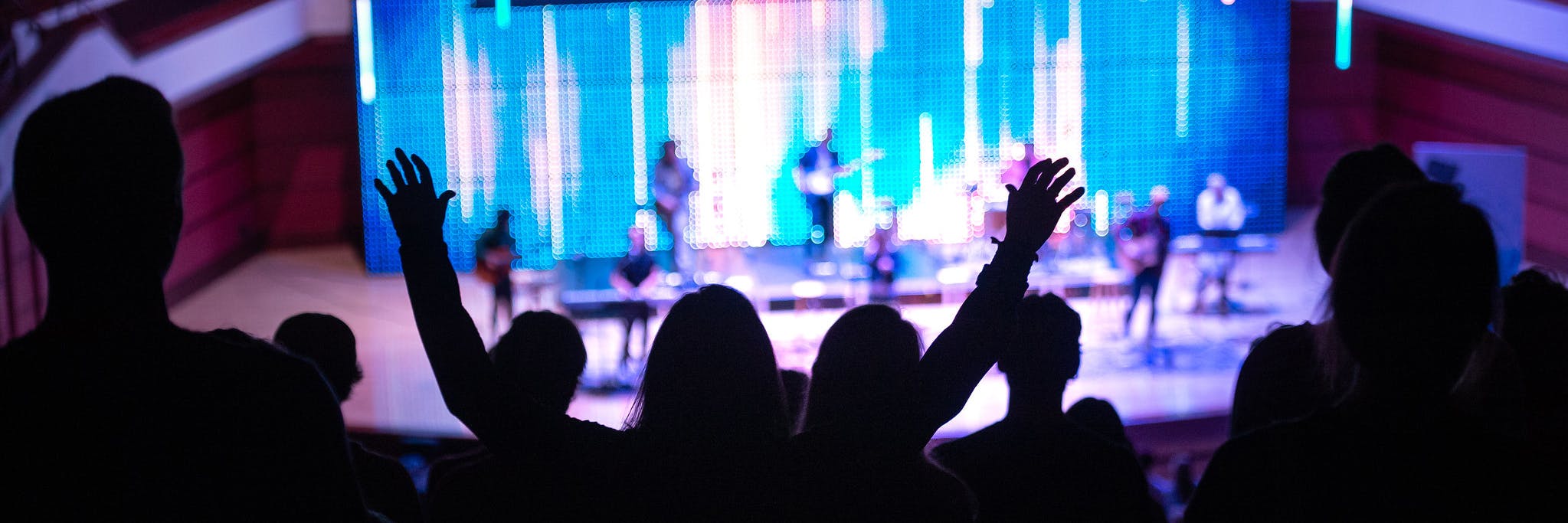 A student raises their hands in worship at weekly Chapel.
