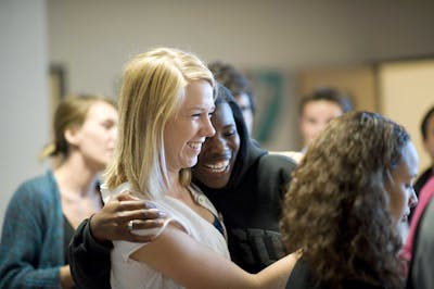 Two students hugging and smiling