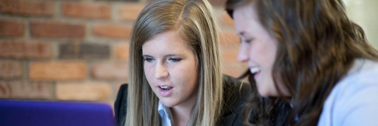 Two people in discussion in front of a computer