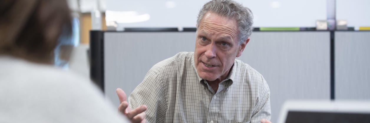 Staff and faculty member speaking together