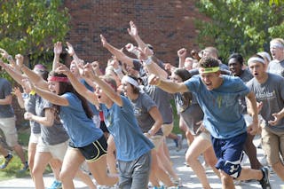 Students running during welcome week move-in.