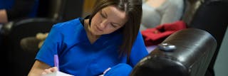 Student taking notes in Bethel University’s Post-Bacc Nursing (B.S.N.) program.