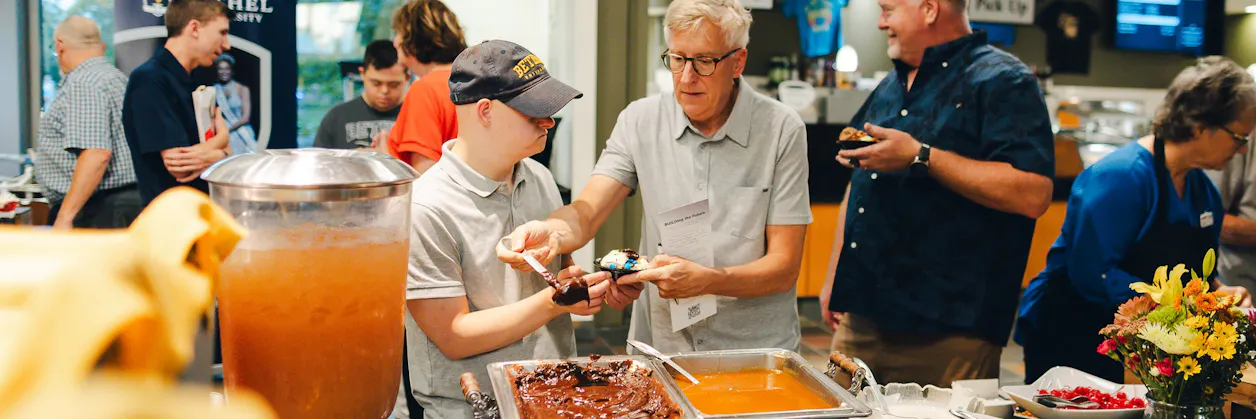 Guests serve dessert from a buffet at a Bethel event.