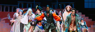Beauty and the Beast cast performing a musical number featuring Gaston.