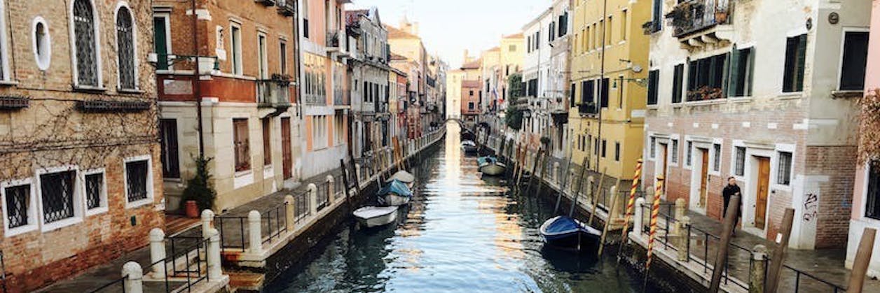 Canal in Venice with colorful buildings on either side.