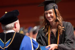 A student receives her diploma from President Jay Barnes at Spring Commencement at Bethel University