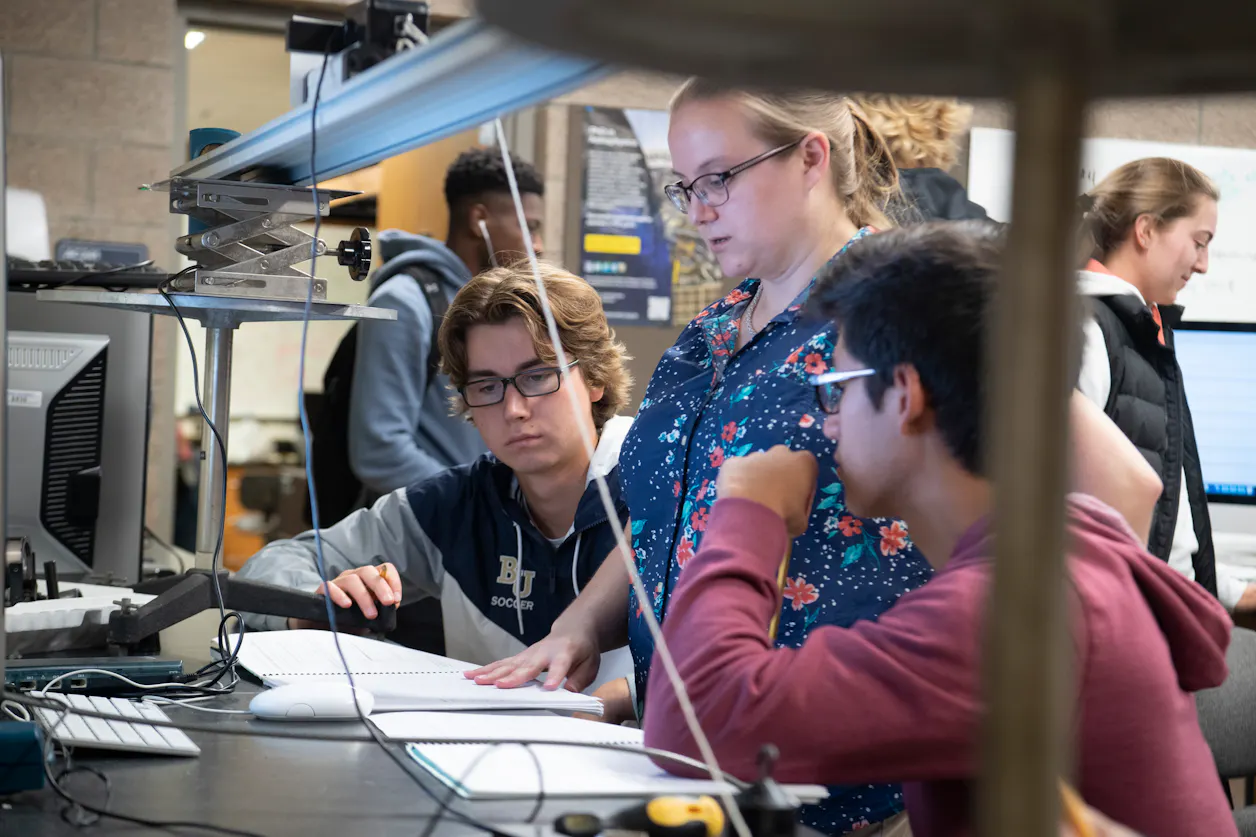 Students and a professor do research in a physics lab at Bethel University.