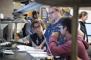 Students and a professor do research in a physics lab at Bethel University.