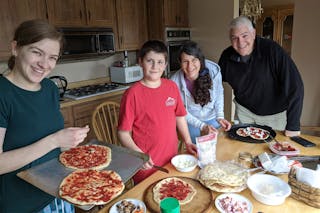 Abigail Gundy '15 (left) makes pizza with her brother Josiah and their parents during quarantine.