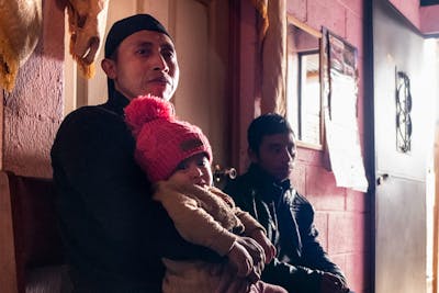 Mardoqueo Tian sits with his daughter, Ana Lucia, in the house they share with Tian’s parents in Tecpán, Guatemala. | Photo by Bryson Rosell