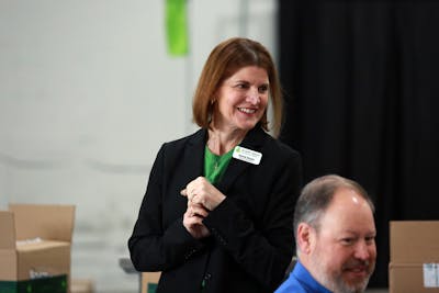 Every Meal Board Chair Jenna Soule chats with long-time supporters during a tour of the nonprofit's warehouse.