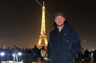 Jaran Roste '21, GS'24 poses near the Eiffel Tower in Paris. 