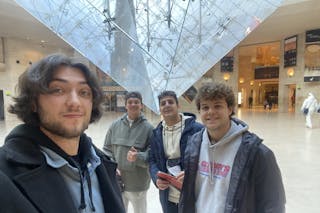 Jaran Roste '21, GS'24 poses at the Louvre Museum with members of the Bethels business department’s study abroad trip in Paris.