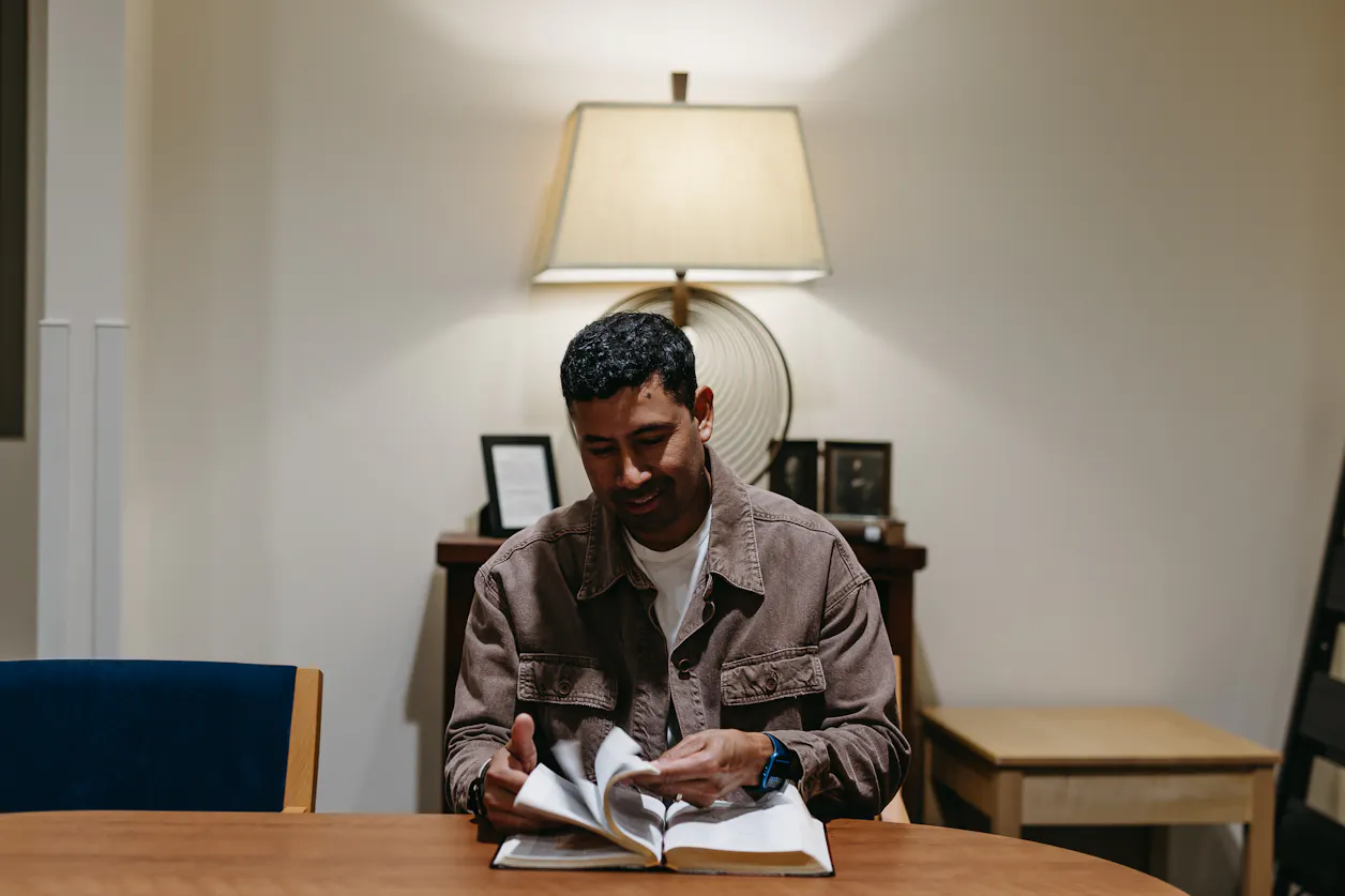 Alex Perla Castillo pages through the Bible in the Bethel Seminary space