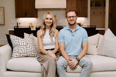 Sparks and her husband Allen sit on a coach in a staged home.
