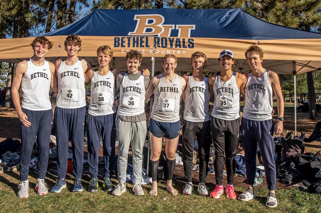 Bethel men’s cross country team poses together under a team tent on race day.