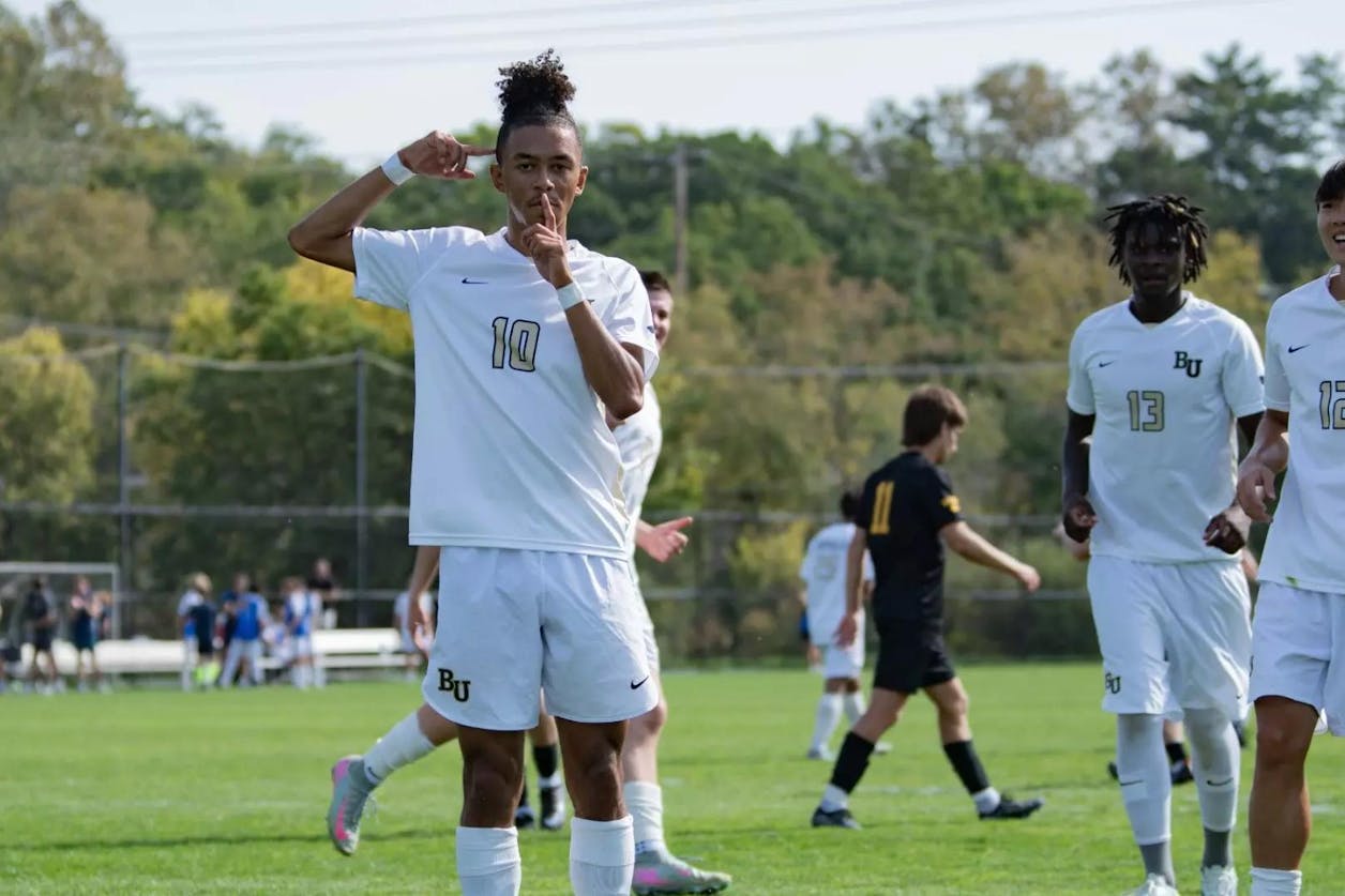 Bethel men’s soccer player gestures to the crowd after scoring a goal.