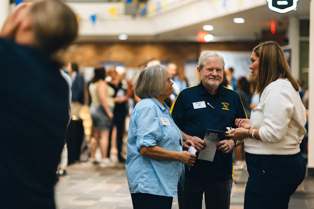 Guests chat in a busy campus atrium during the BUILDing the Future: 10 Years of Impact event at Bethel.