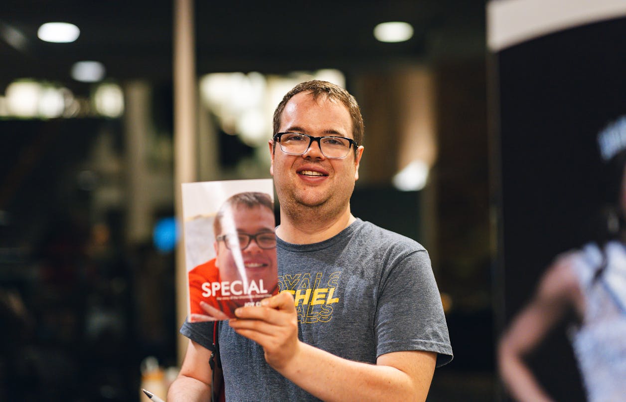 A former student in BUILD proudly holds a book featuring his own story. 