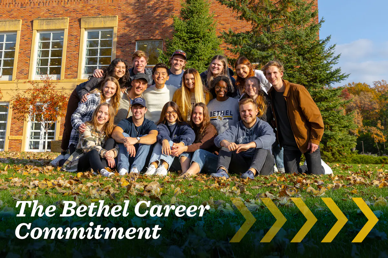 Group of smiling Bethel students posing together outside on a sunny fall day.