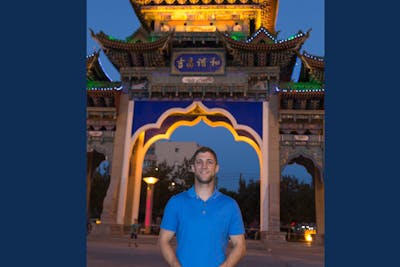 Kevin Pieh ‘06 standing in front of an arched landmark during his time in China