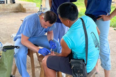 PA student Nate Chau treats a man's broken finger during a clinical rotation in Panama