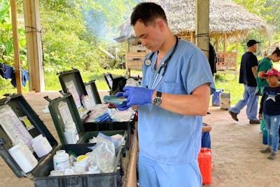 PA student Nate Chau readies supplies at a mobile clinic through Floating Doctors