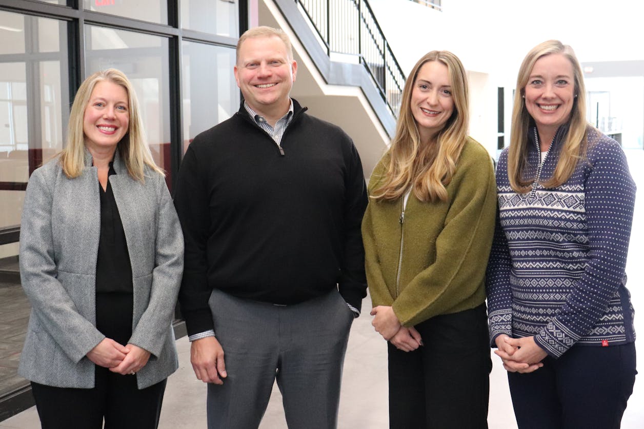Teresa Widen, Nathan Flansburg, Shawn Lohse, and Lara Bronson pose together inside PACT Charter School.