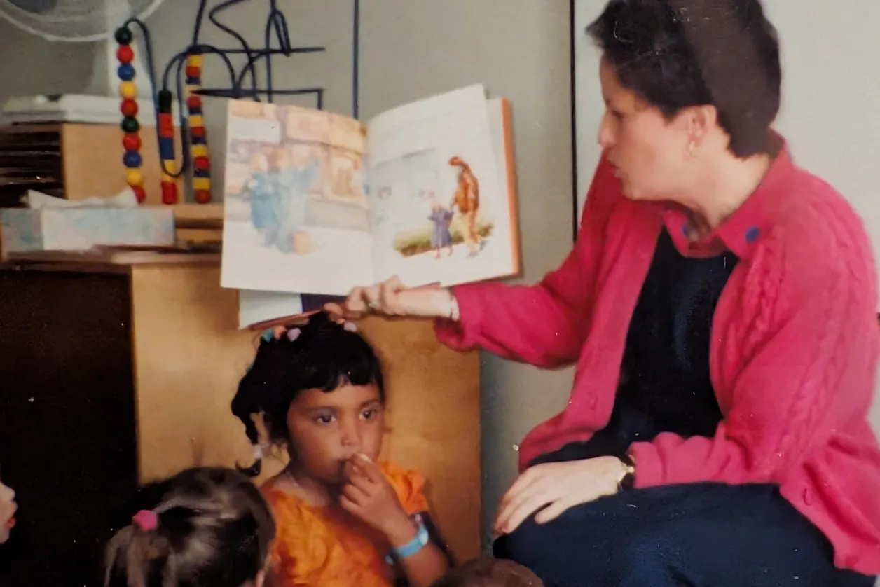 Young Sarah Peterson sitting beside her mom at Bethel University’s Child Development Center during a parent reading day in the early 1990s.