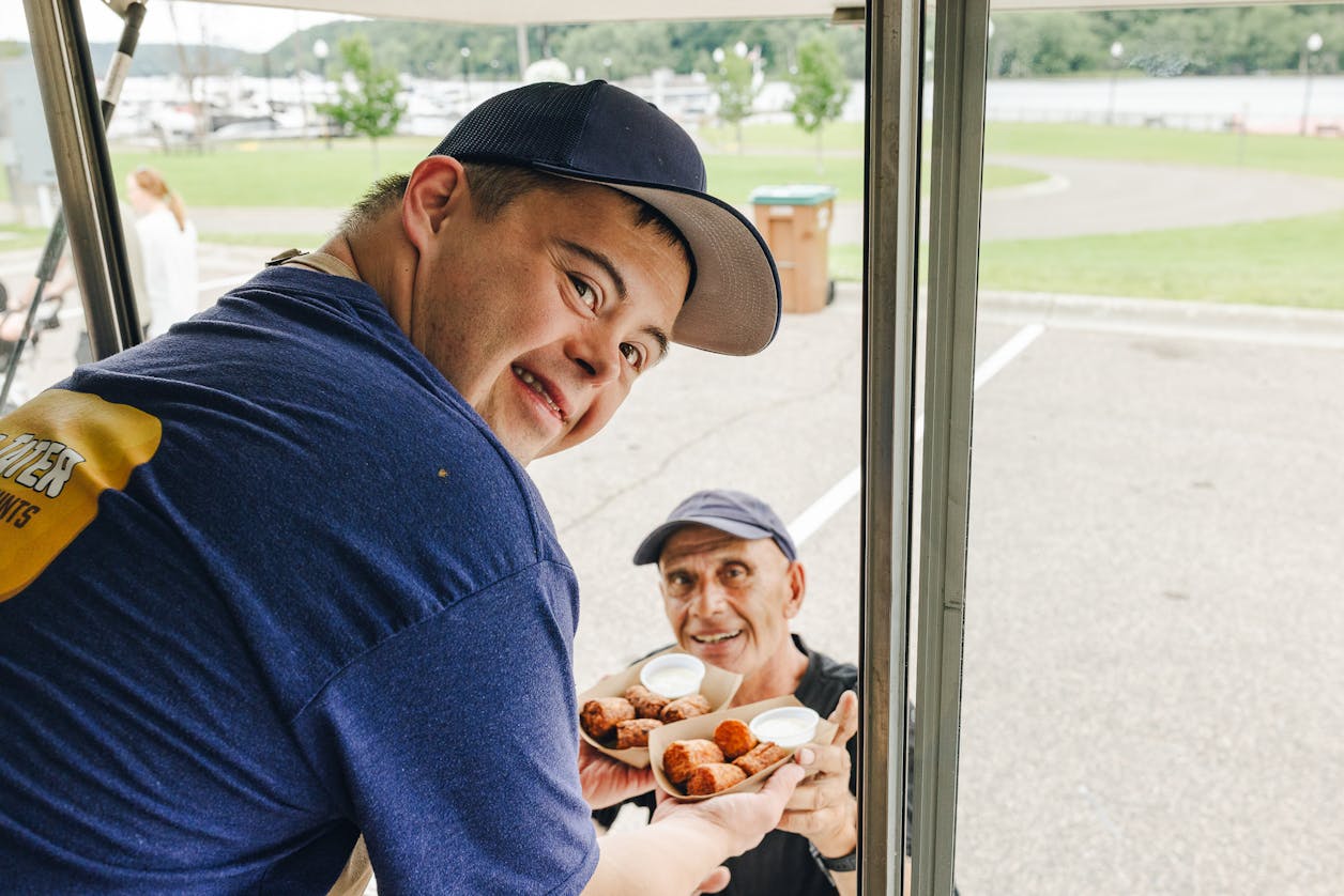 David serves taters to a customer out his food truck window