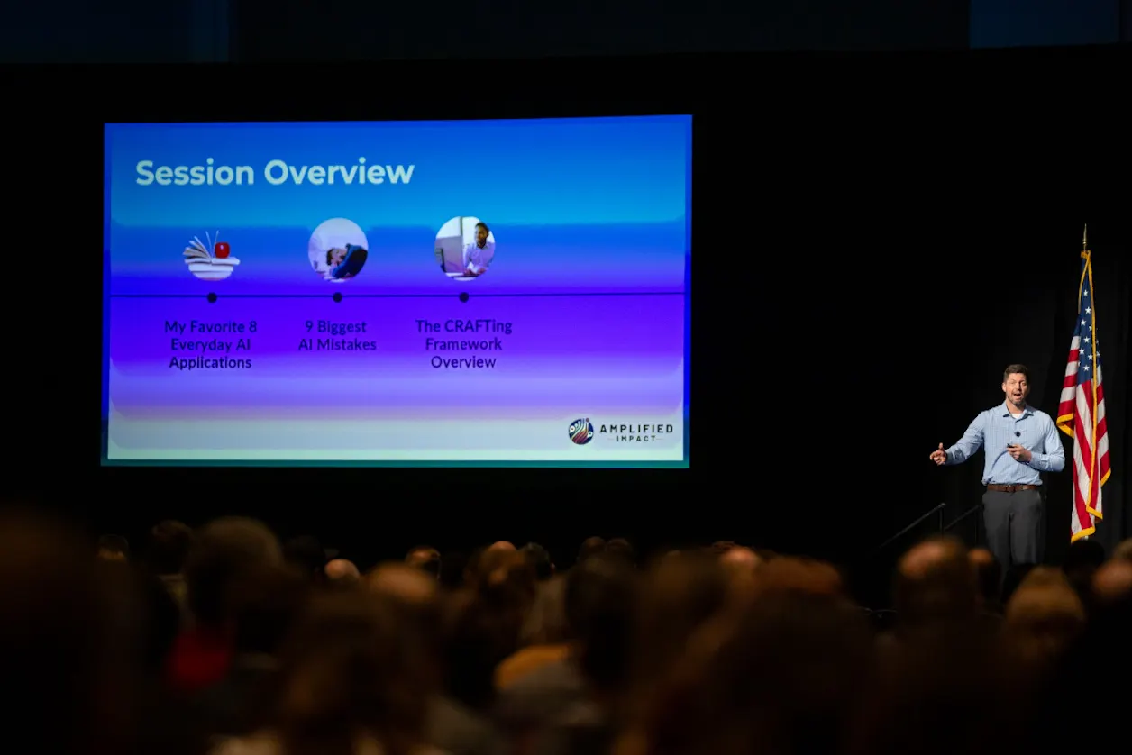 Moberg stands on stage with a large presentation screen and an American flag in the background. The presentation screen is providing a session overview for the presentation.