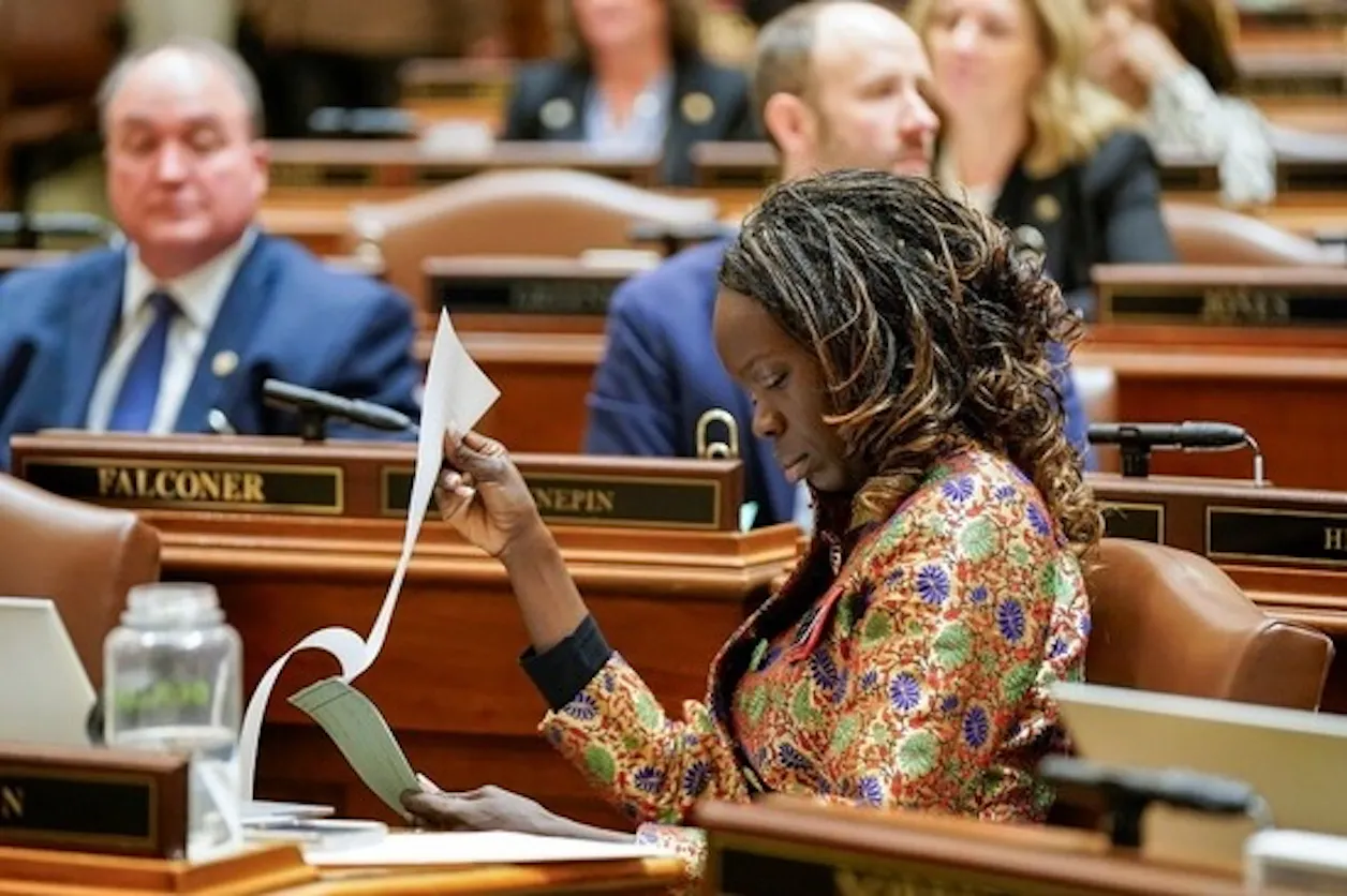 Woman reviews documents while seated on the Minnesota House floor.