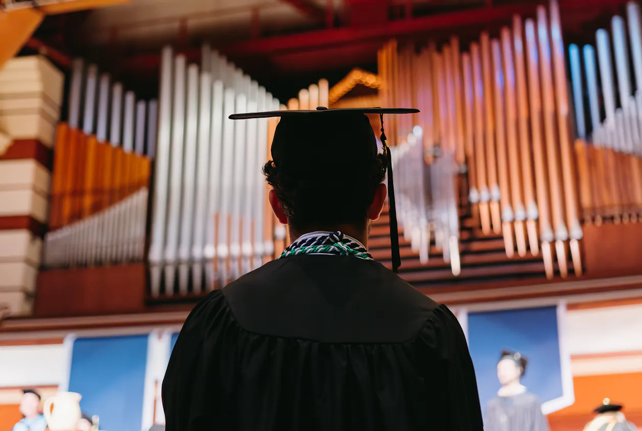 Male student looks up at the organ at commencement