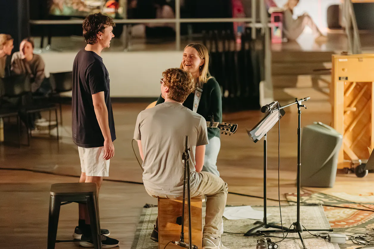 Students talk after a worship set in the underground 