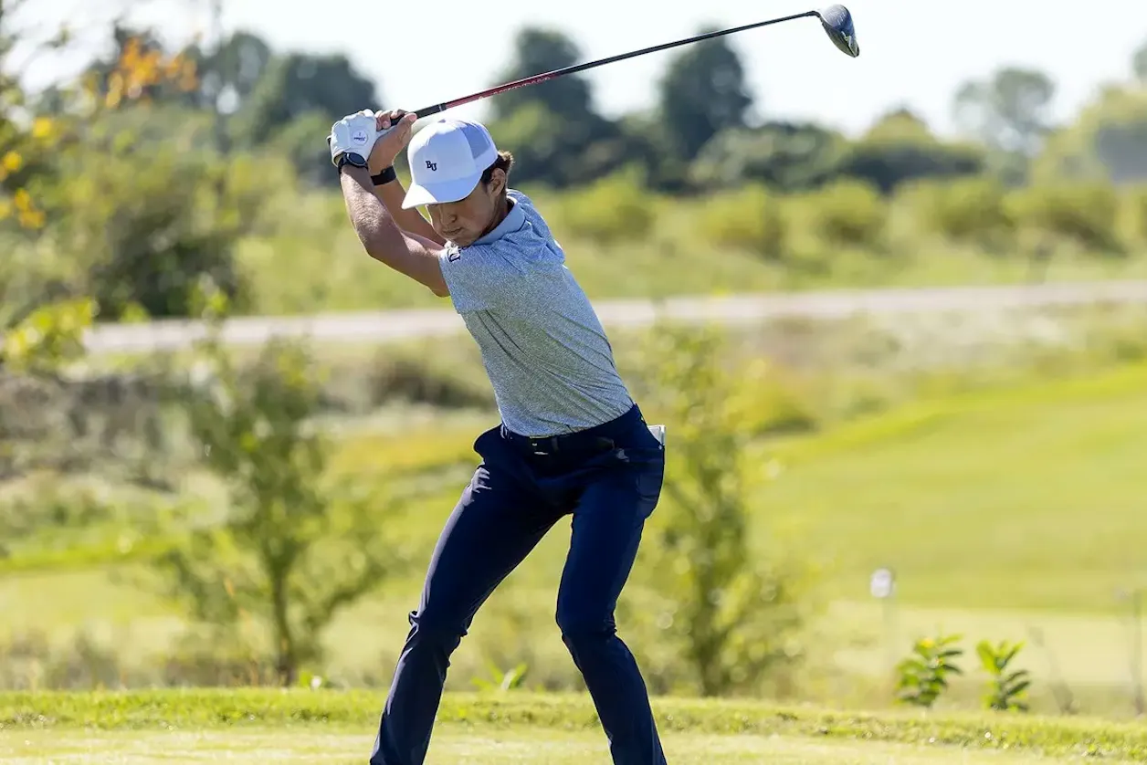 Bethel men's golfer swings a driver during a tournament round.
