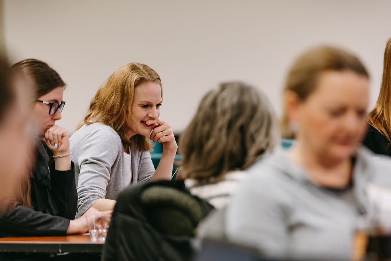 Participants listen and take notes during a classroom-style professional development session.