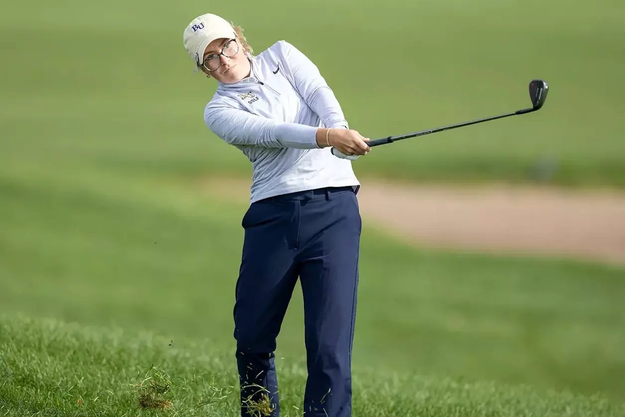 Bethel women's golfer hits an approach shot from the rough during competition.