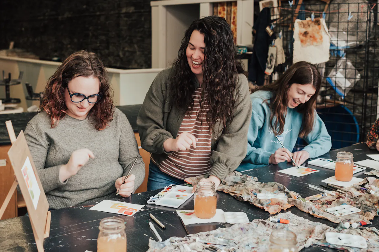 Alyssa Whetstone '19 works with adults in an art studio, teaching them the basics of watercolor painting. 