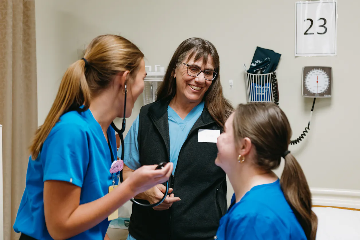 Debbie Solomon works with students in Bethel's nursing lab