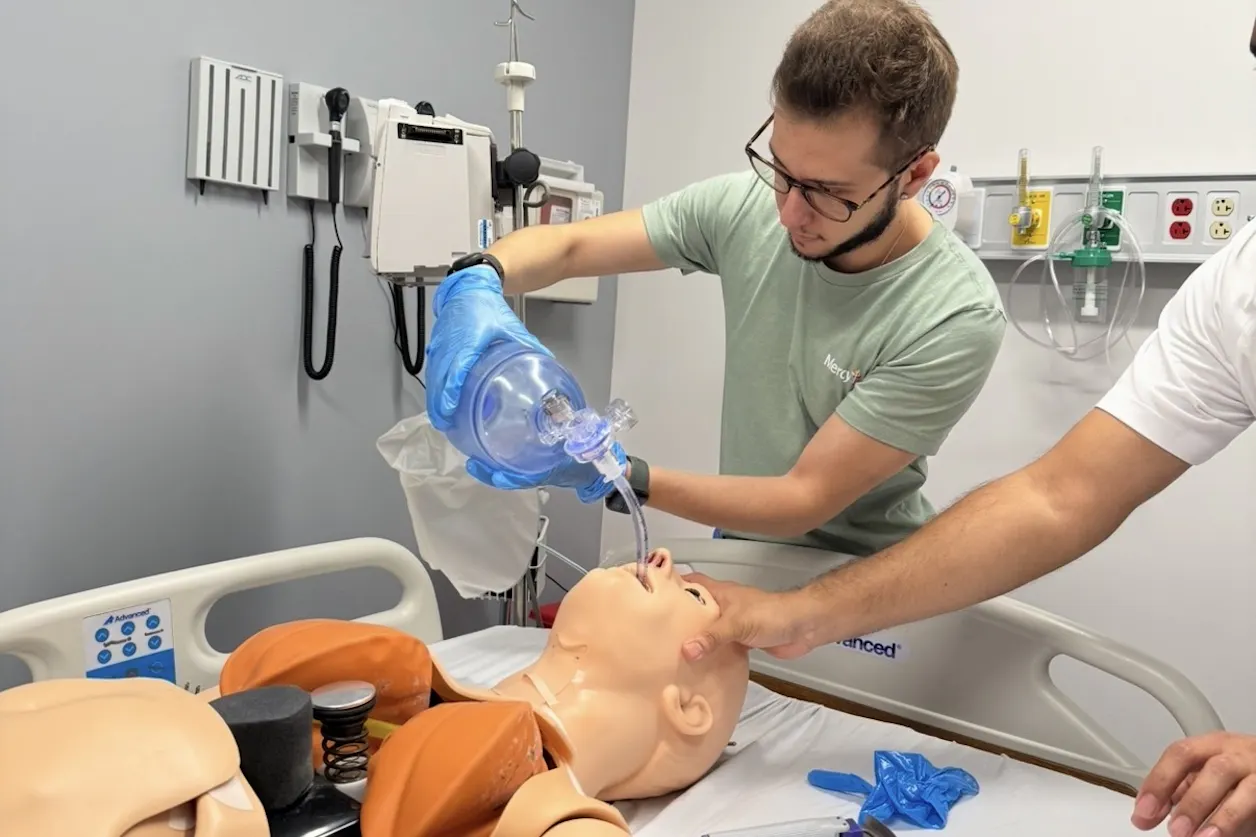 Ivan Nunez GS'24 practices medical skills on a dummy.