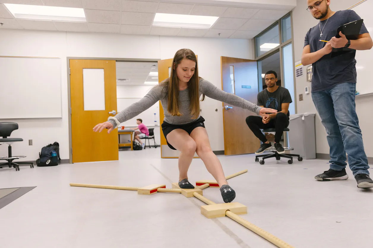 Professor and students discussing exercise science concepts. 