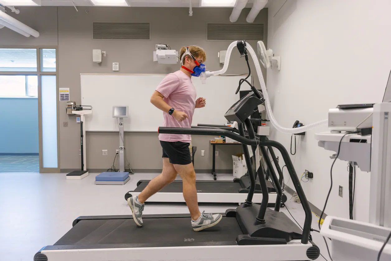 Student running on a treadmill with a breathing apparatus. 