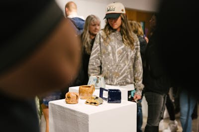 Ceramic artworks displayed on pedestals in an art gallery. 