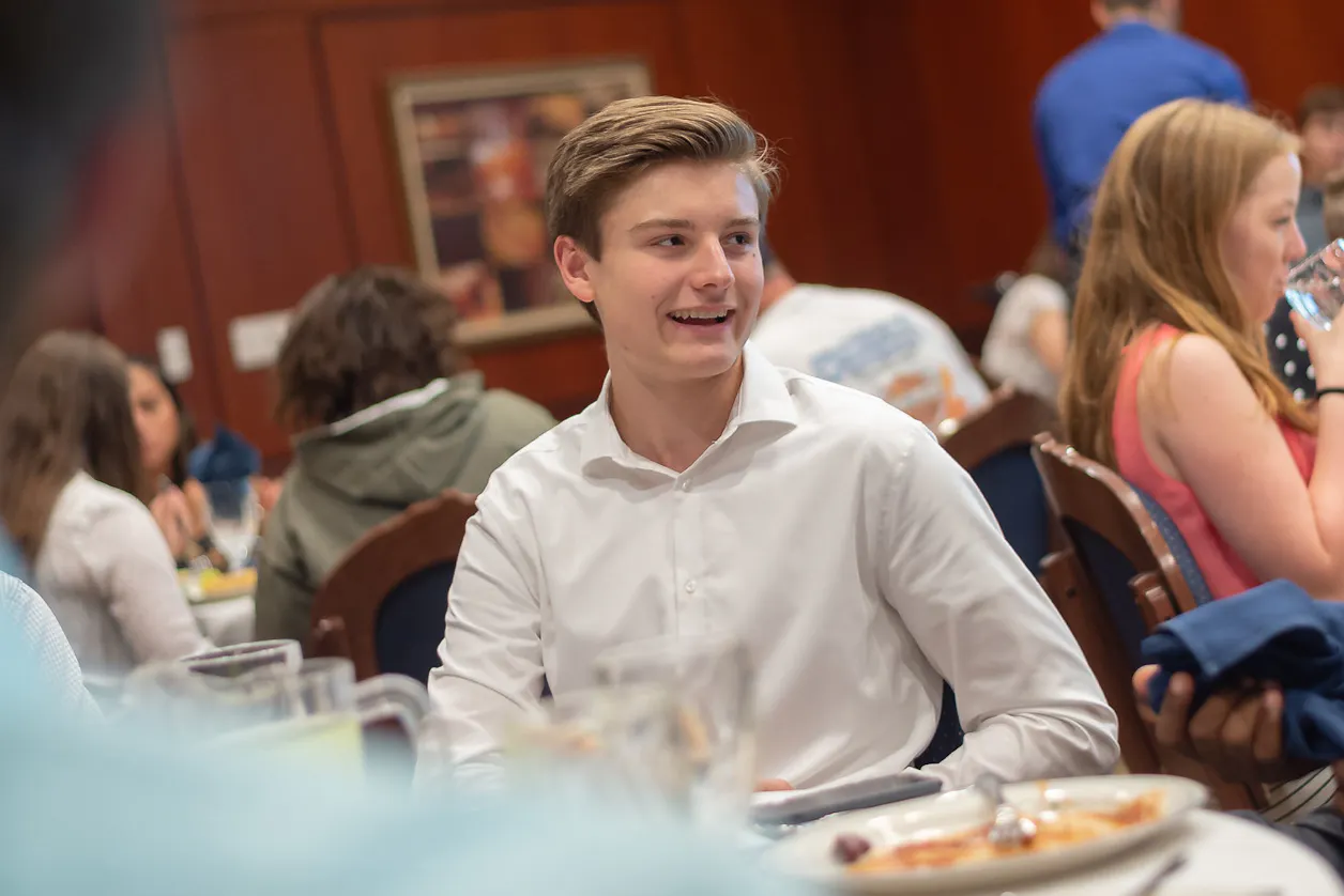 guy in white button-down smiling at an event 