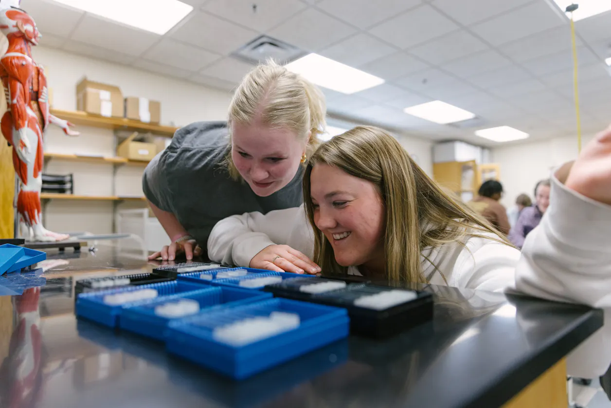 Two students excitedly examine samples during a lab exercise.