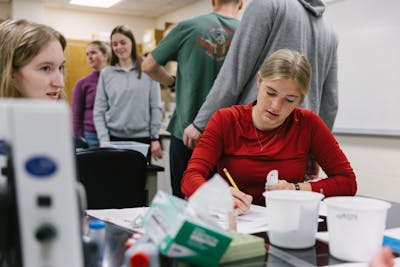 Students discuss and work together in a biology lab.