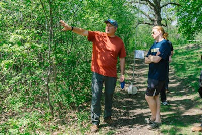 A professor is explaining something to a student in a lush