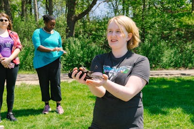 A student is holding a blackbird