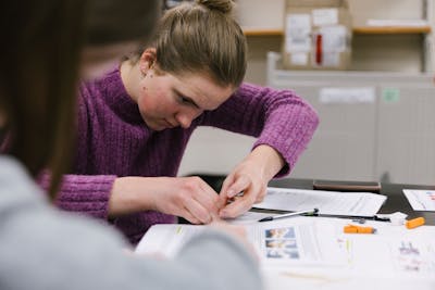 Engaged student participating in an introductory biology class, surrounded by interactive learning materials.