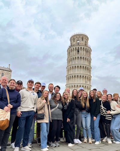 A group of students posing in front of the Leaning Tower of Pisa during a study abroad trip.